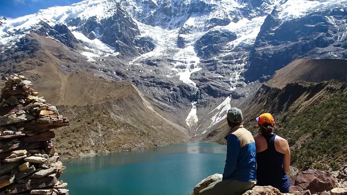 Travelers at Humantay Lake viewpoint with Salkantay Glacier and turquoise lake