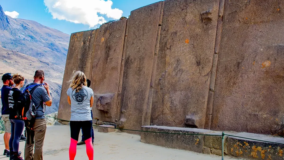 Travelers at the Wall of Six Monoliths in Ollantaytambo on the Sacred Valley and Machu Picchu Tour