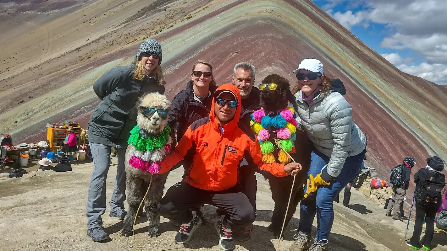 Tourists with decorated alpacas at Rainbow Mountain Vinicunca on the Rainbow Mountain Trek